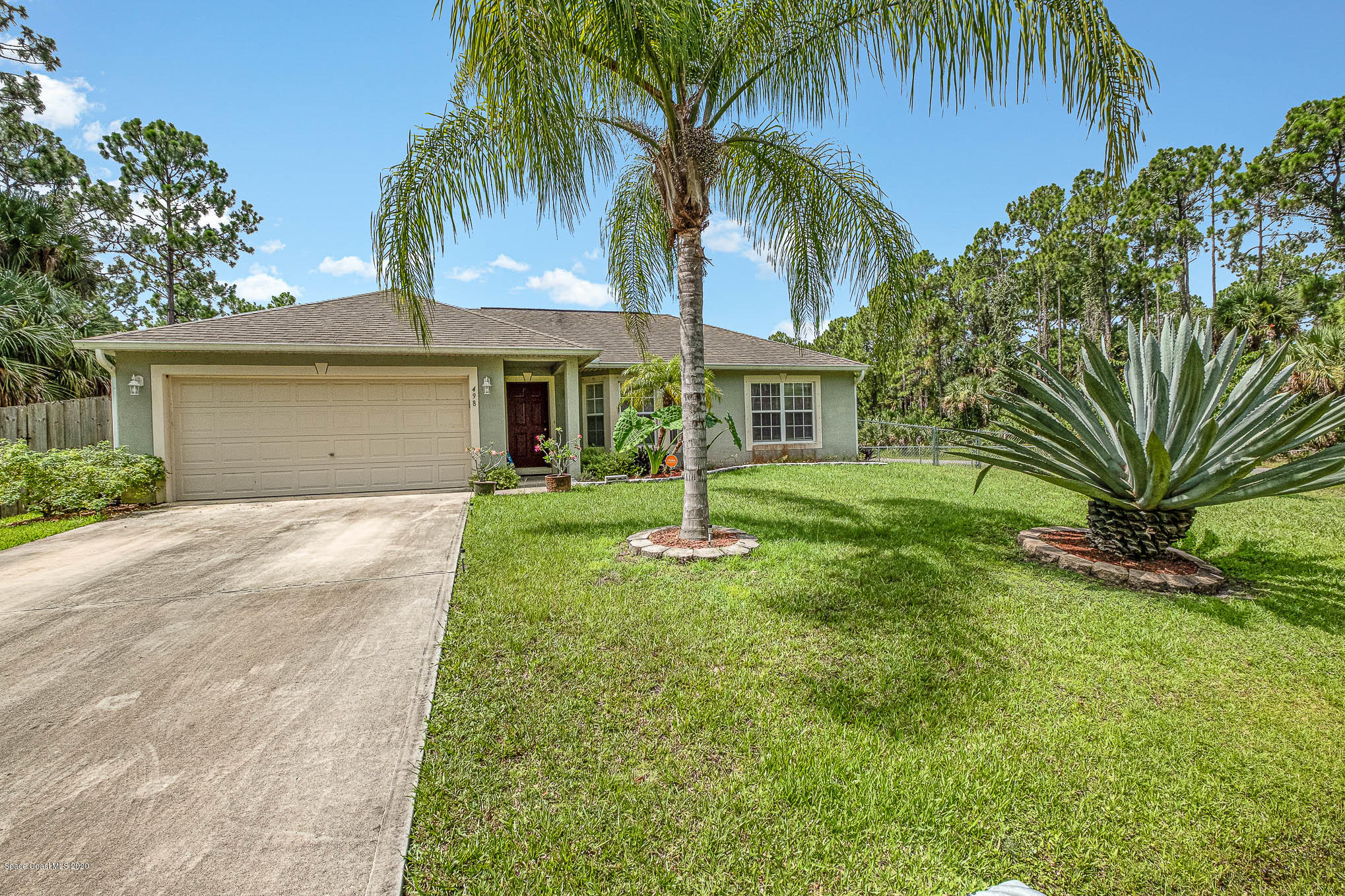 498 Scarlet Road Southwest Palm Bay, FL 32908 - Photo 1 of 24 a front view of house with yard and green space