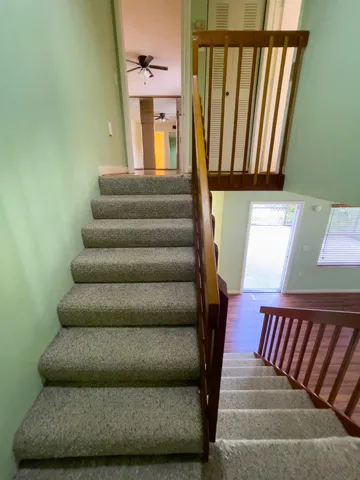 a view of a big room with wooden floor and a ceiling fan