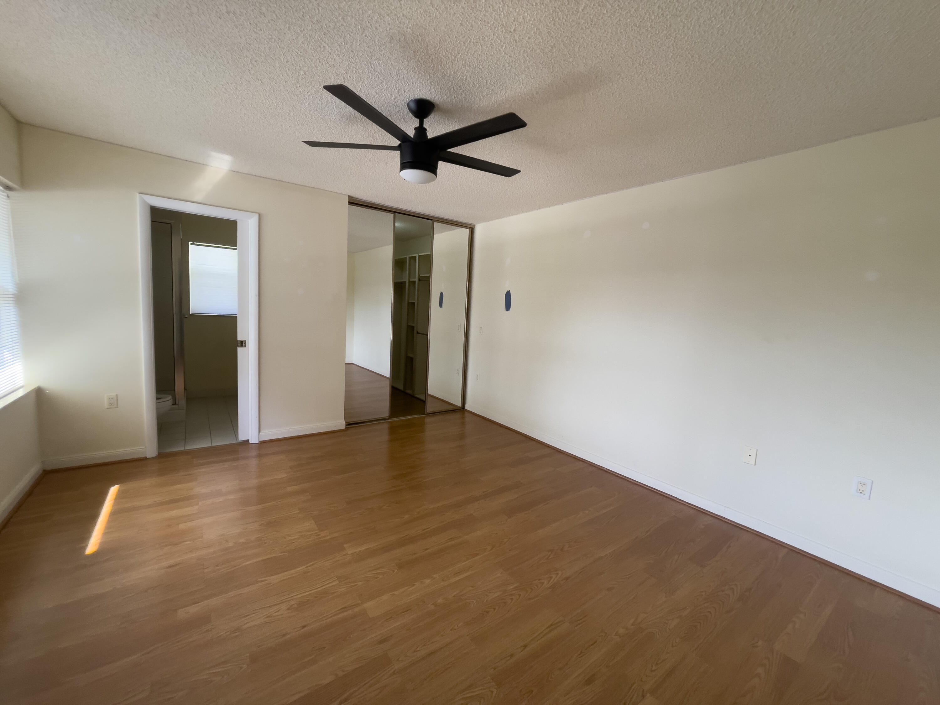 27 Clinton Court, Unit D Royal Palm Beach, FL 33411 - Photo 15 of 32 a view of a big room with wooden floor and a ceiling fan