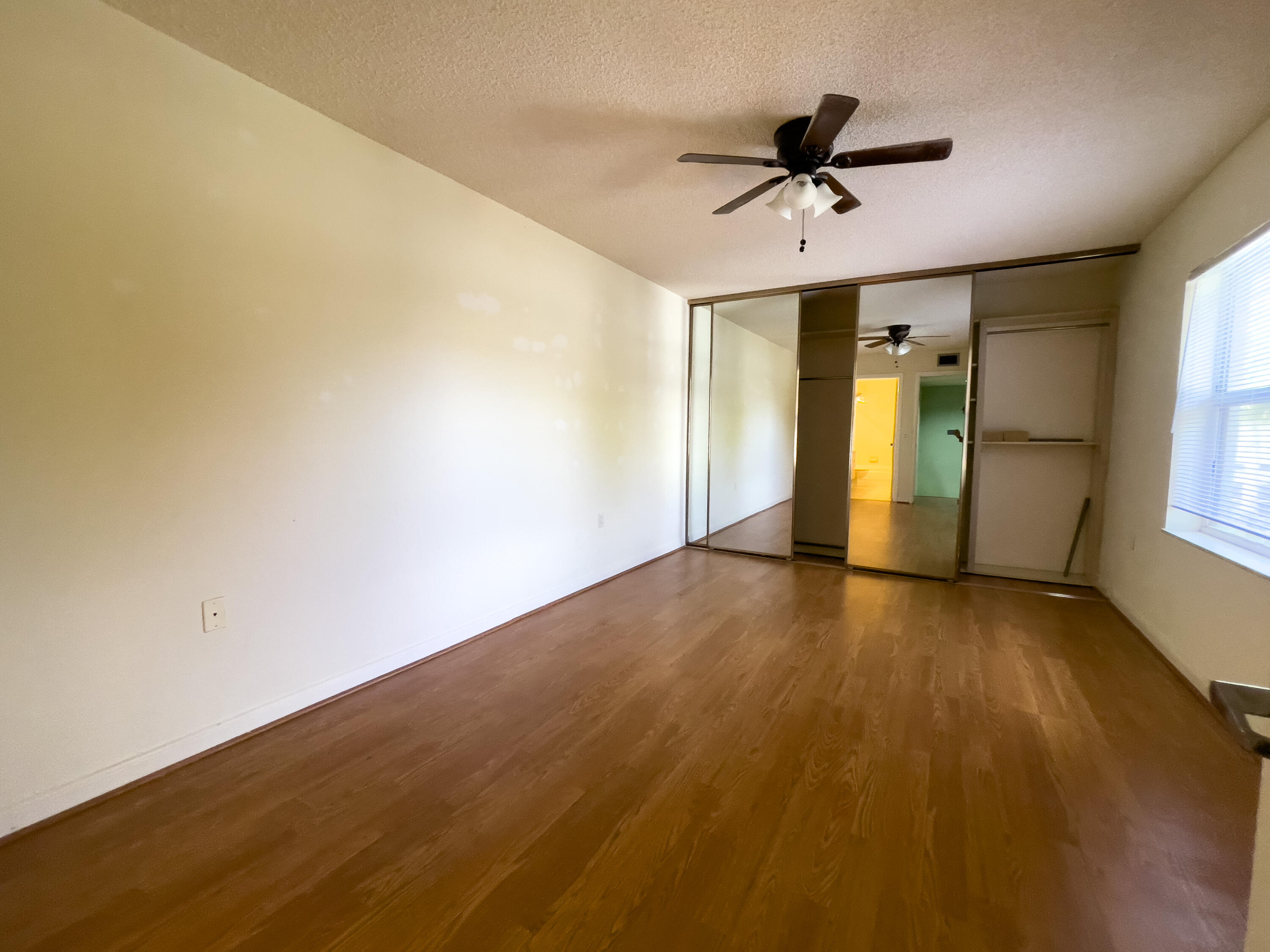 27 Clinton Court, Unit D Royal Palm Beach, FL 33411 - Photo 18 of 32 wooden floor in an empty room with a window