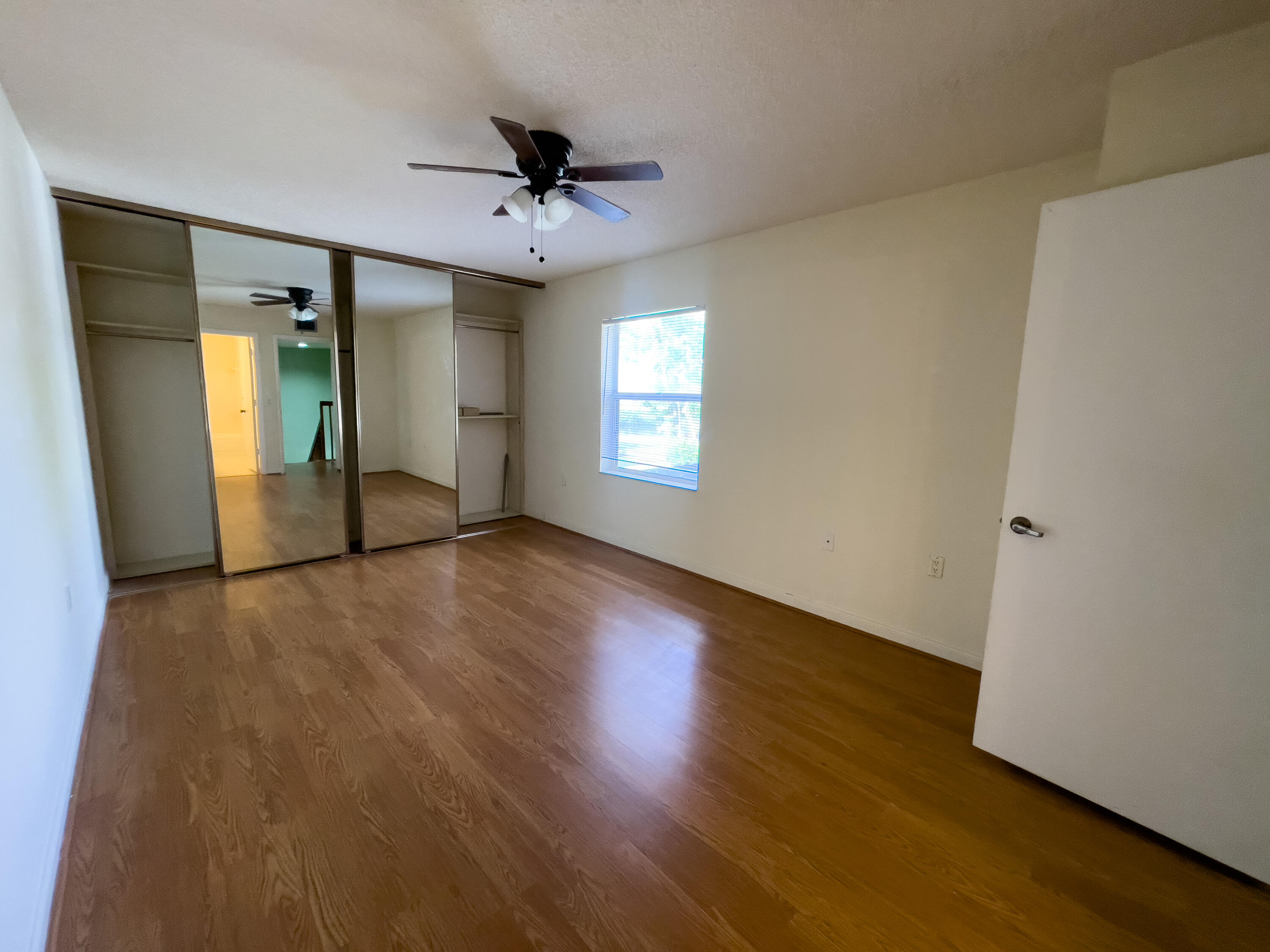 27 Clinton Court, Unit D Royal Palm Beach, FL 33411 - Photo 20 of 32 a view of an empty room with window and wooden floor