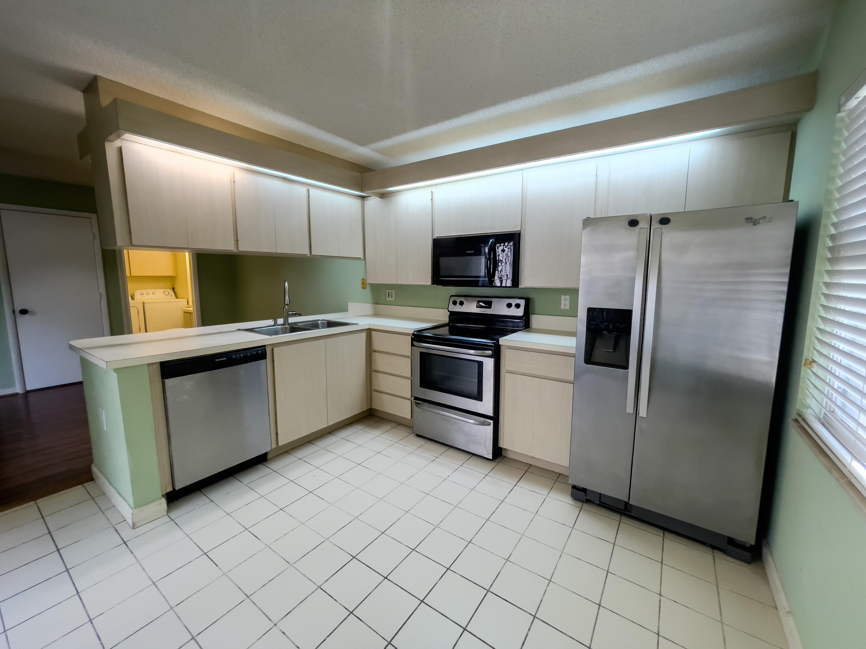 27 Clinton Court, Unit D Royal Palm Beach, FL 33411 - Photo 22 of 32 a kitchen with stainless steel appliances a refrigerator sink and microwave