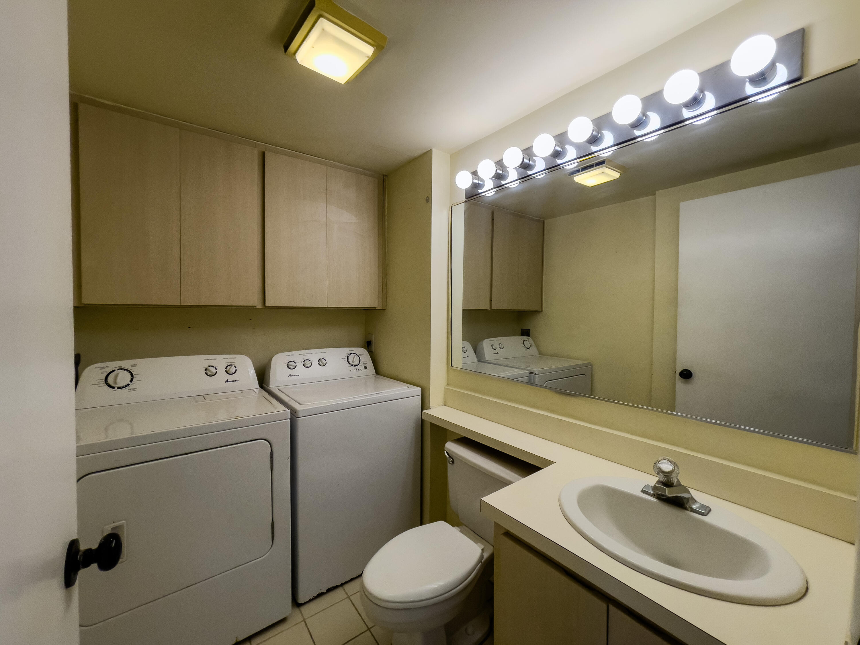27 Clinton Court, Unit D Royal Palm Beach, FL 33411 - Photo 23 of 32 a bathroom with a sink mirror and toilet