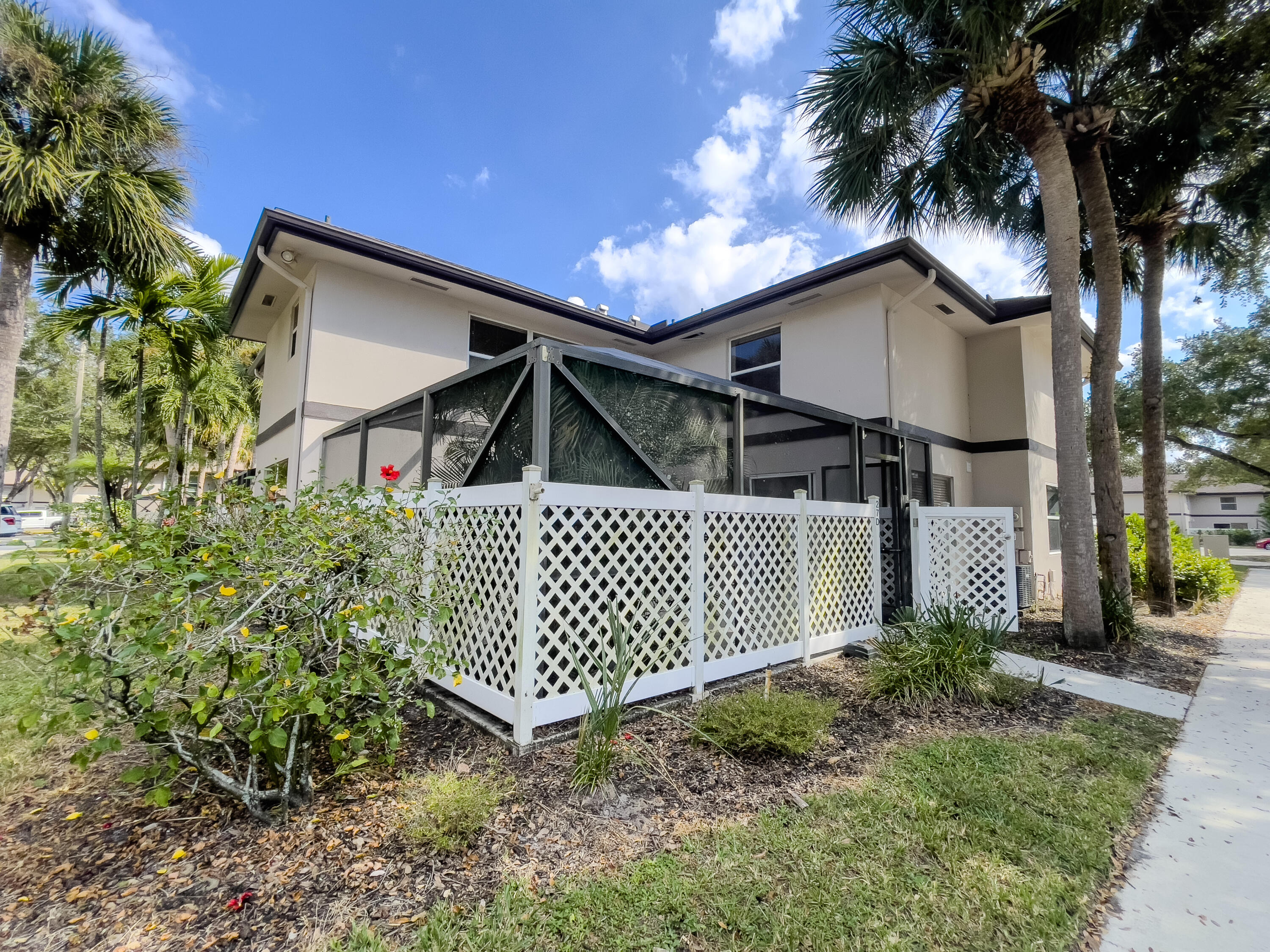 27 Clinton Court, Unit D Royal Palm Beach, FL 33411 - Photo 3 of 32 a view of a house with a small yard and flower plants