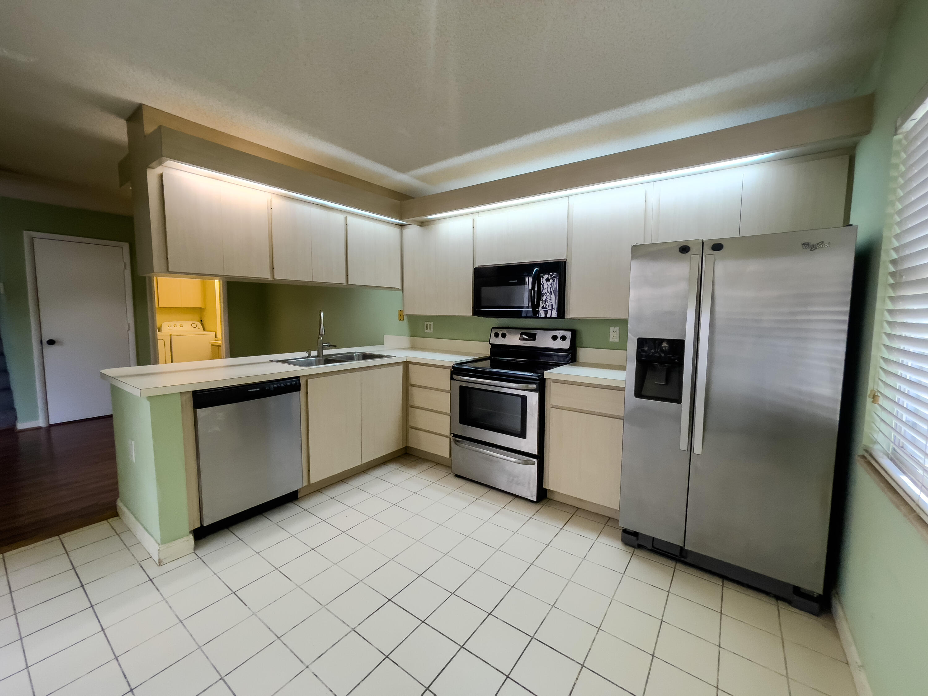 27 Clinton Court, Unit D Royal Palm Beach, FL 33411 - Photo 7 of 32 a kitchen with a sink stainless steel appliances and cabinets