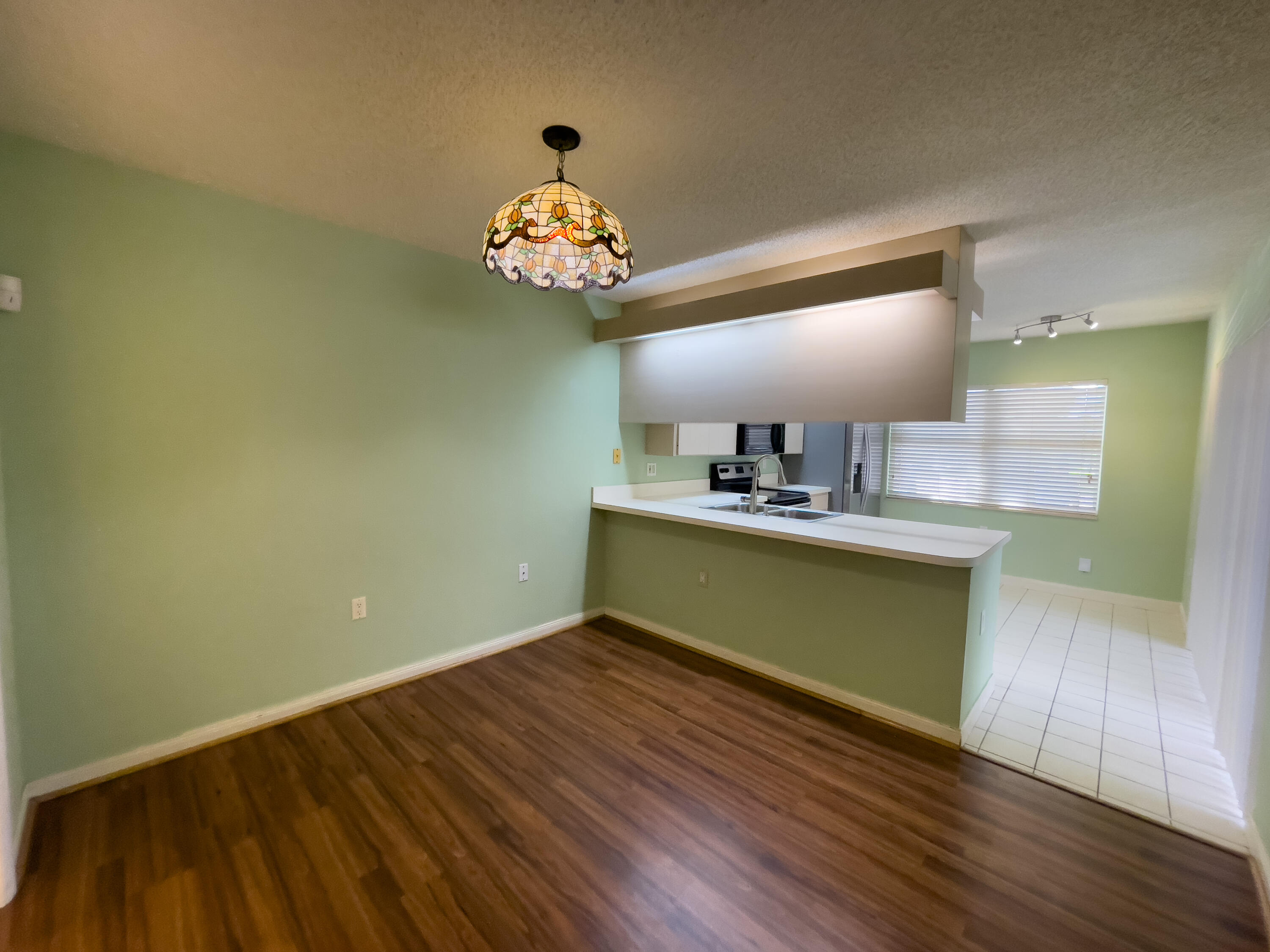 27 Clinton Court, Unit D Royal Palm Beach, FL 33411 - Photo 10 of 32 a view of kitchen and kitchen with wooden floor