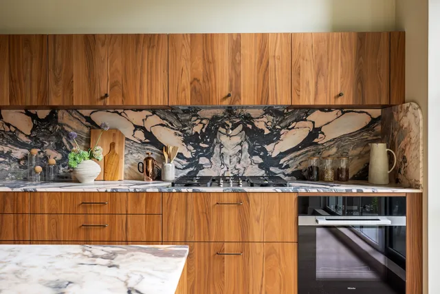 a kitchen with stainless steel appliances a stove a sink and white cabinets