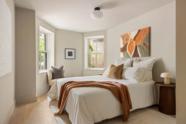 a bedroom with a bed and painting on the wall