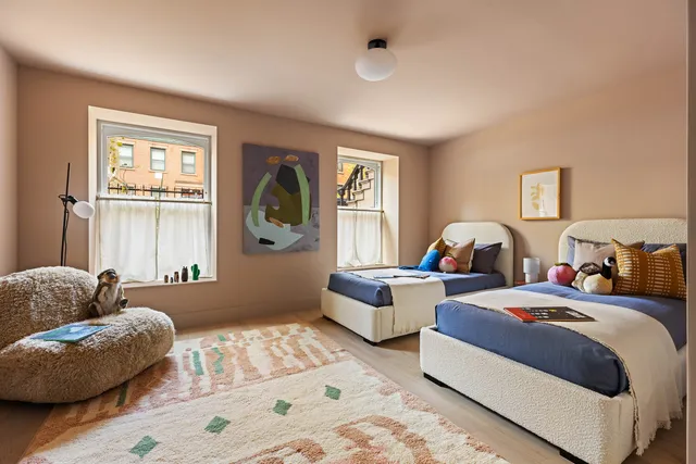 a bedroom with two beds and a large window