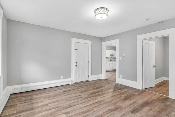 an empty room with wooden floor and window