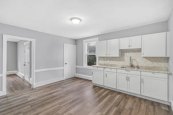 a kitchen with granite countertop white cabinets and white appliances
