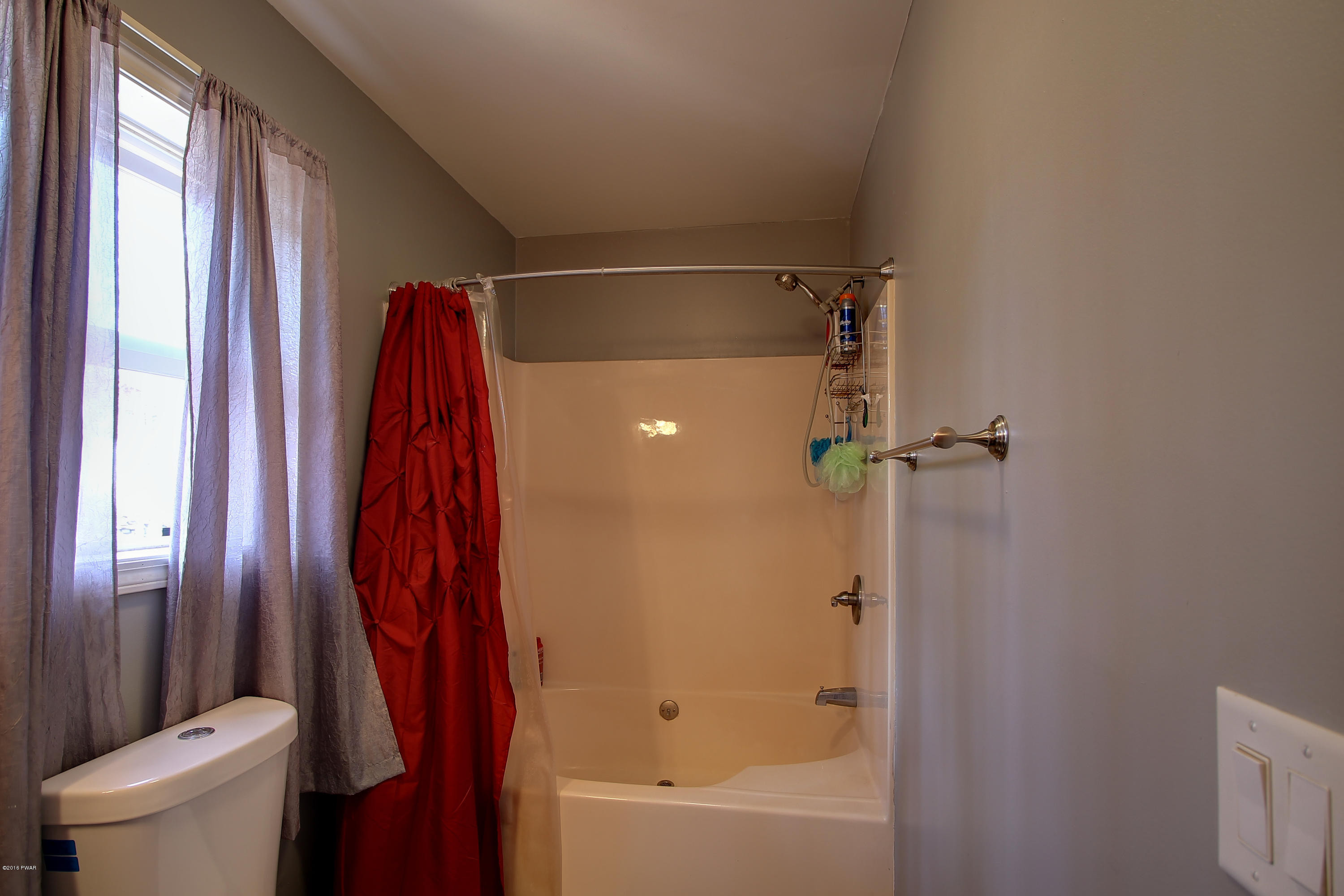5630 Haas Pond Road Moscow, PA 18444 - Photo 21 of 42 a bathroom with a shower curtain and a toilet