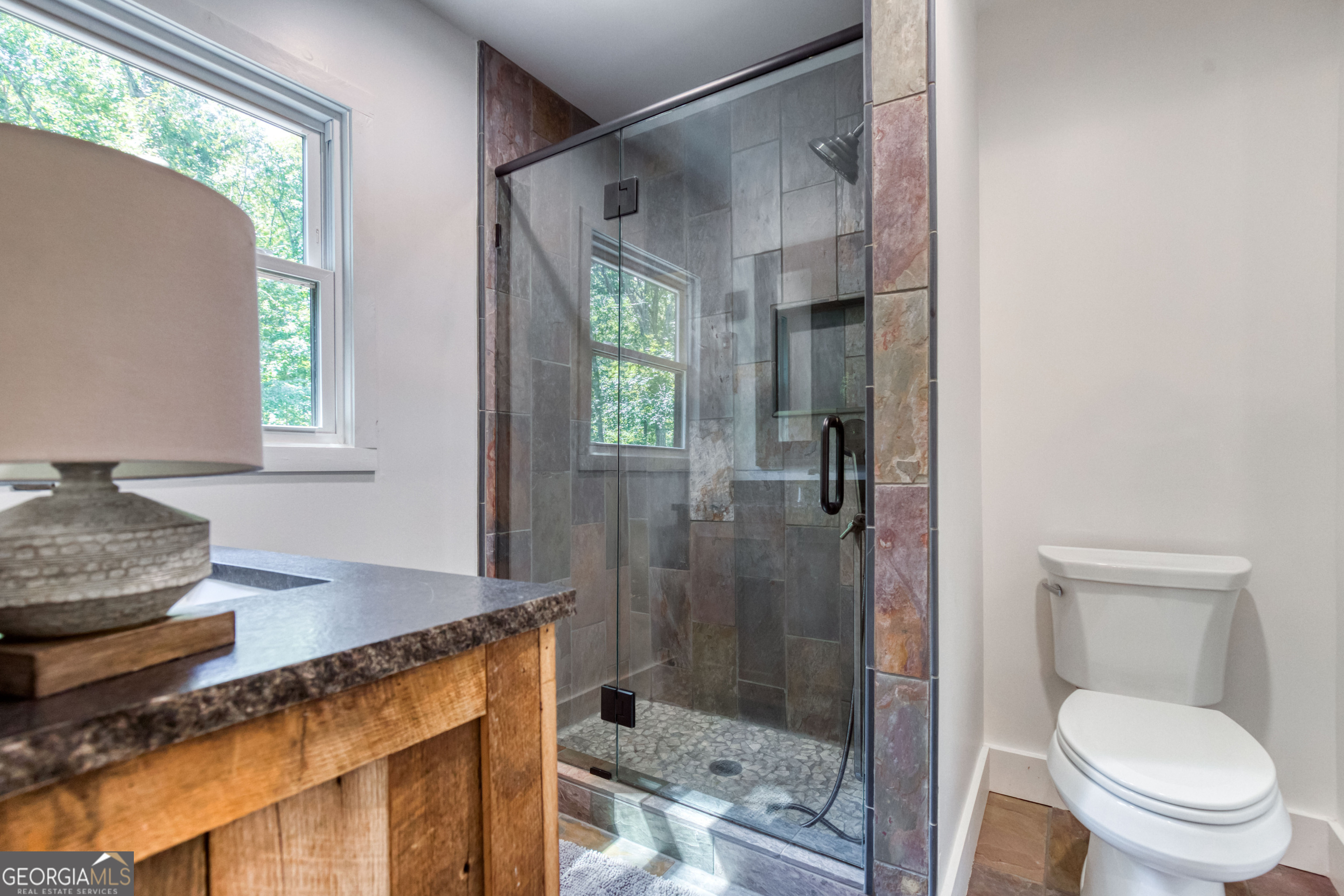1968 Bobby Brown State Park Road Elberton, GA 30635 - Photo 87 of 97 a bathroom with a granite countertop sink a toilet and shower