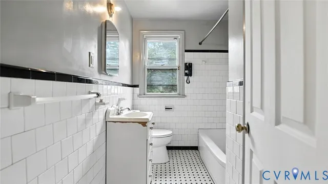 a bathroom with a sink a toilet a mirror and shower