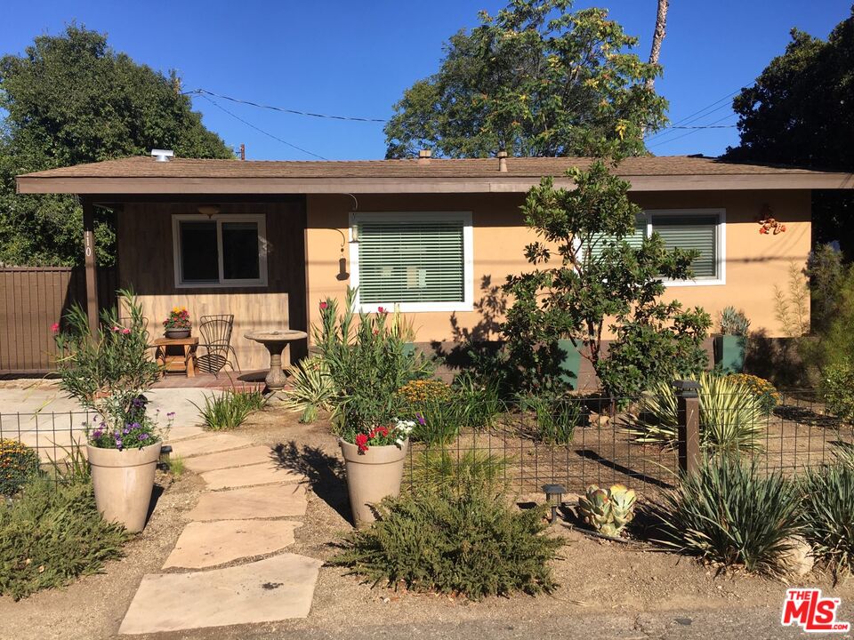 a view of a house with potted plants