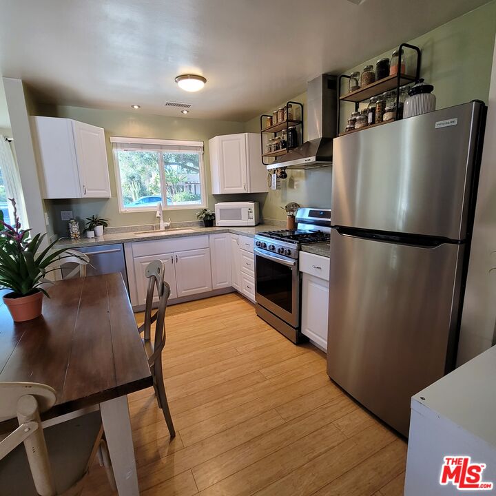 110 Canada Street Ojai, CA 93023 - Photo 11 of 36 a kitchen with granite countertop a refrigerator a sink a stove and cabinets