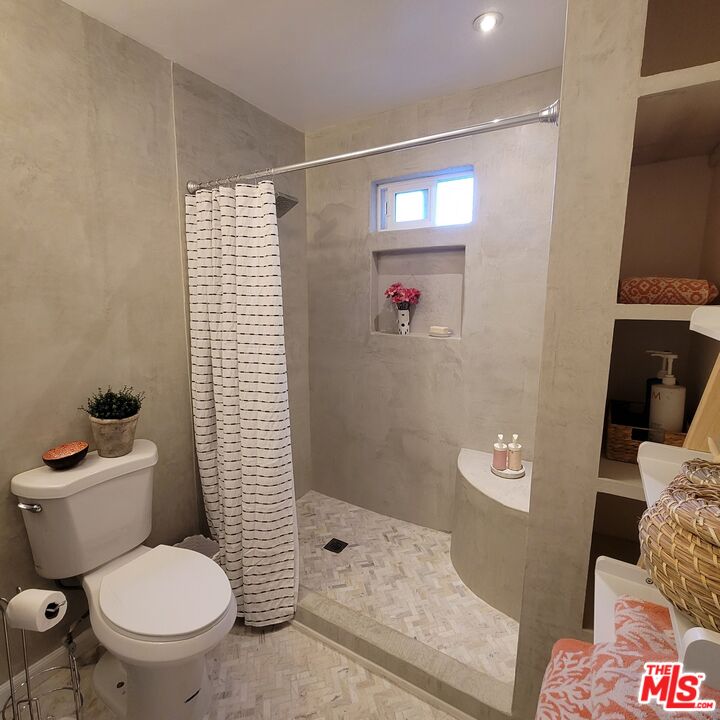 110 Canada Street Ojai, CA 93023 - Photo 17 of 36 a white toilet sitting next to a shower curtain