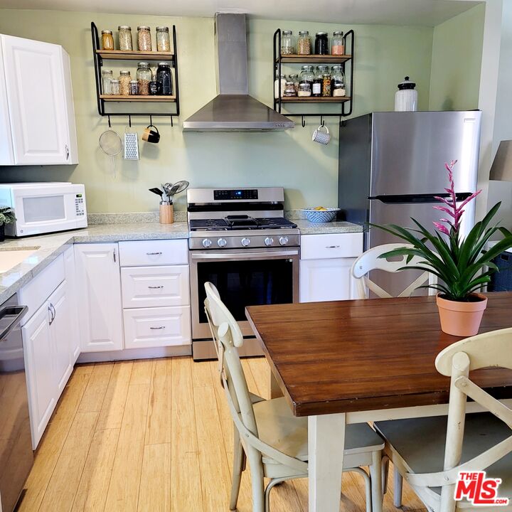 110 Canada Street Ojai, CA 93023 - Photo 9 of 36 a kitchen with stainless steel appliances granite countertop a stove top oven a sink dishwasher and cabinets with wooden floor