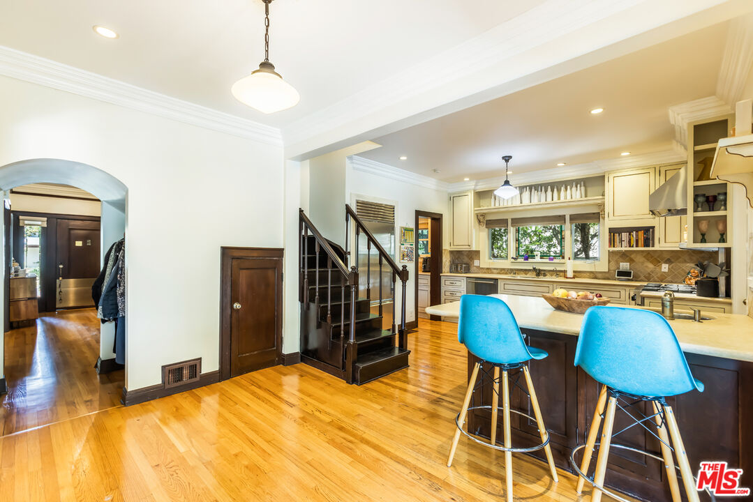 1808 Buckingham Road Los Angeles, CA 90019 - Photo 23 of 75 a kitchen with stainless steel appliances kitchen island granite countertop dining table chairs and a living room view