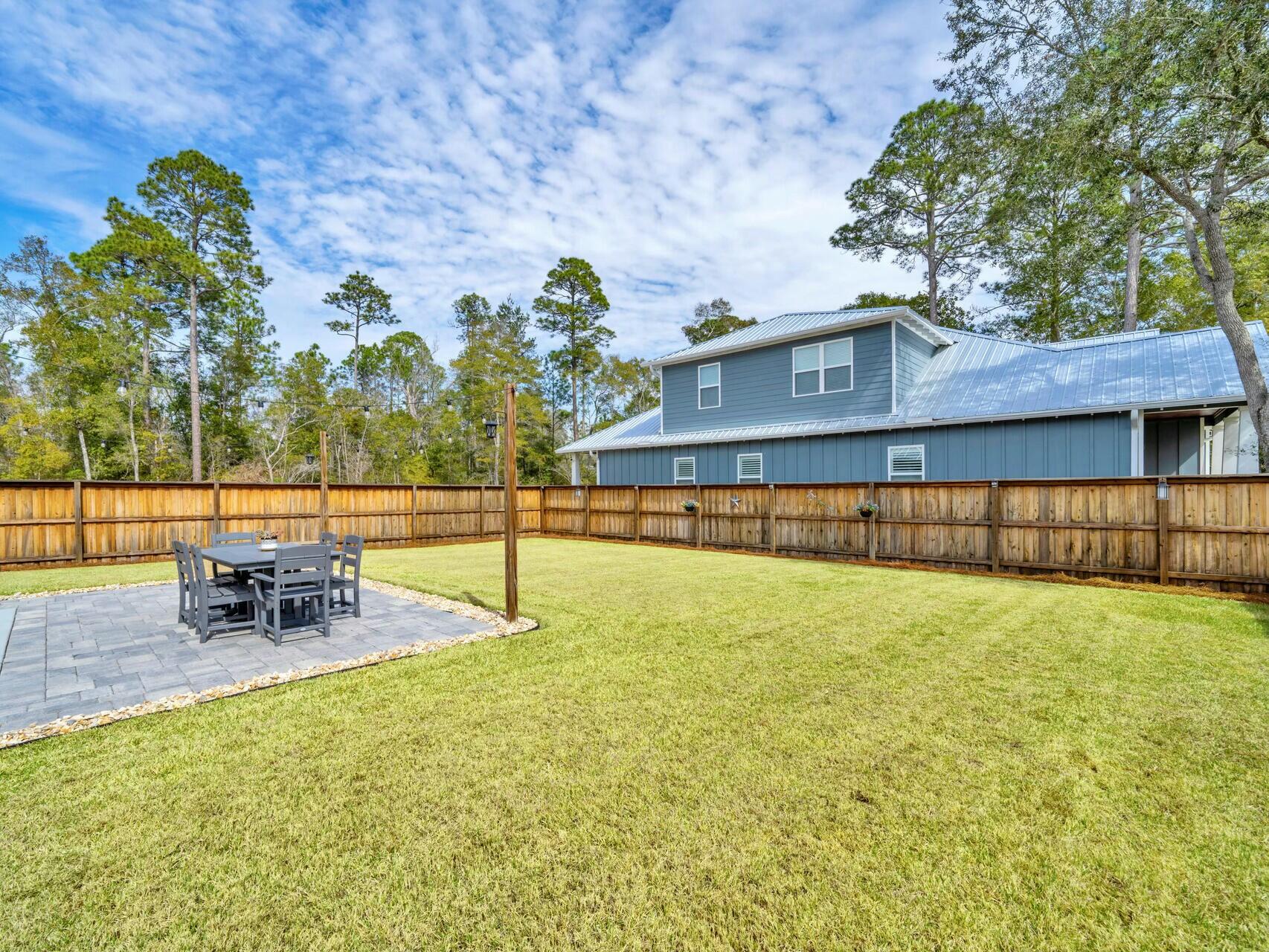 176 Hibernate Way Freeport, FL 32439 - Photo 27 of 66 a view of a swimming pool with a bench and trees in the background