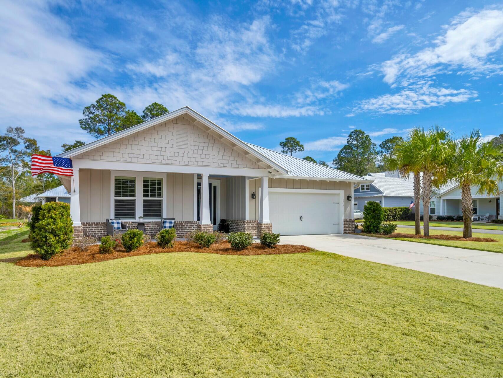 176 Hibernate Way Freeport, FL 32439 - Photo 3 of 66 a front view of a house with a garden and patio