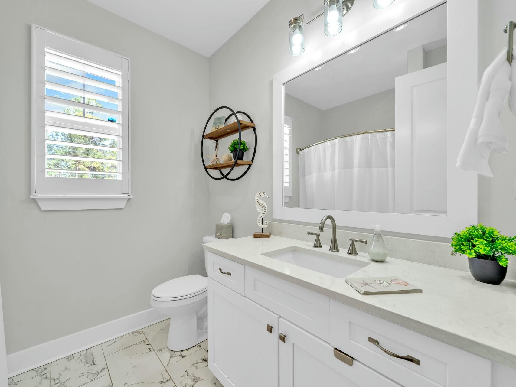 176 Hibernate Way Freeport, FL 32439 - Photo 43 of 66 a bathroom with a toilet a sink a vanity and a mirror