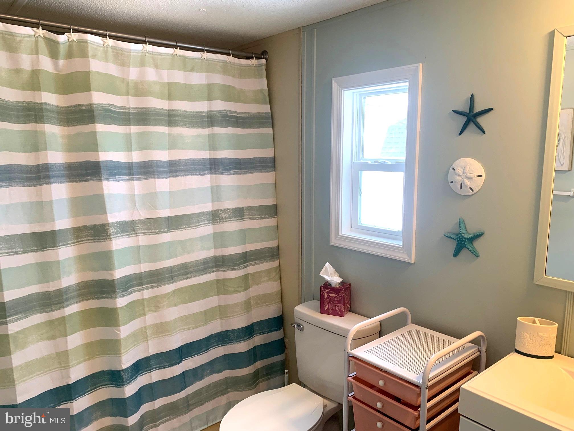 21229 M Street Rehoboth Beach, DE 19971 - Photo 11 of 23 a bathroom with a sink toilet and shower