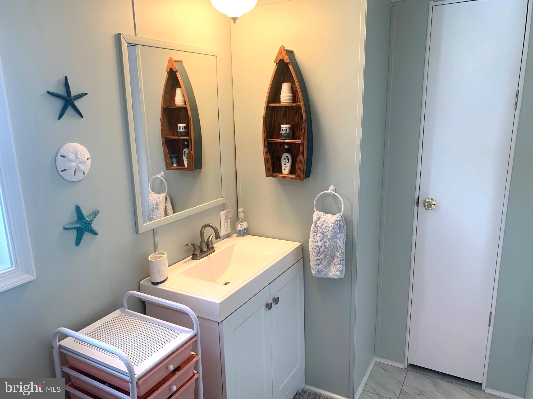 21229 M Street Rehoboth Beach, DE 19971 - Photo 12 of 23 a bathroom with double vanity sink and mirror