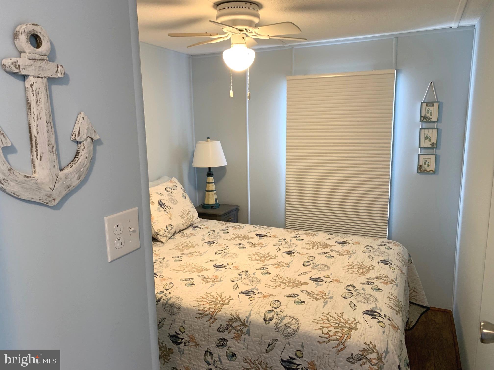 21229 M Street Rehoboth Beach, DE 19971 - Photo 14 of 23 a bedroom with a bed and a chandelier