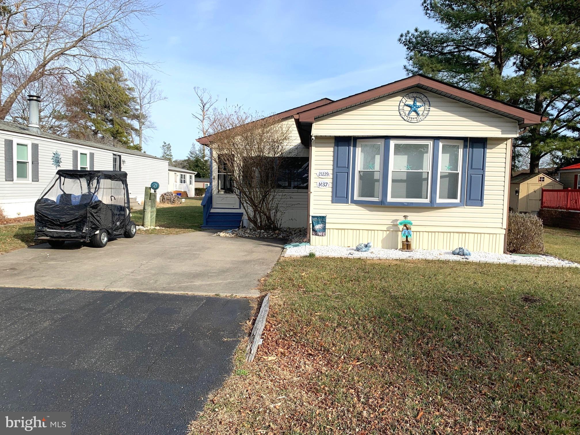 21229 M Street Rehoboth Beach, DE 19971 - Photo 2 of 23 a front view of a house with a yard and garage