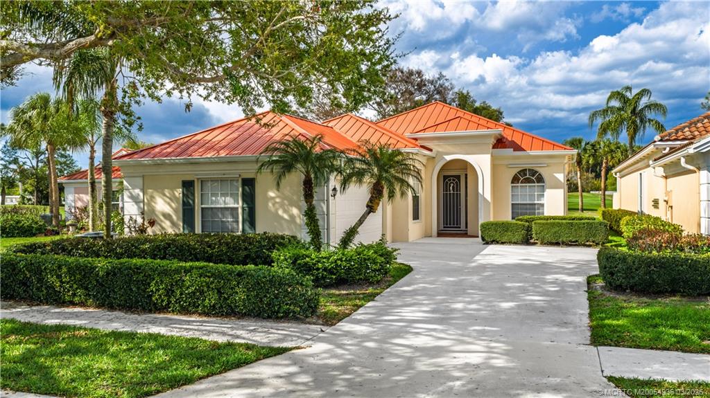 1477 Southwest Eagleglen Place Stuart, FL 34997 - Photo 1 of 36 a front view of a house with a yard and potted plants