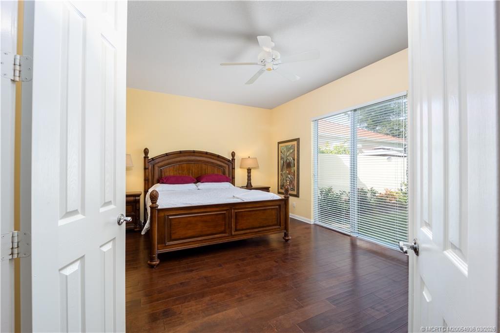 1477 Southwest Eagleglen Place Stuart, FL 34997 - Photo 13 of 36 a bedroom with a bed and wooden floor