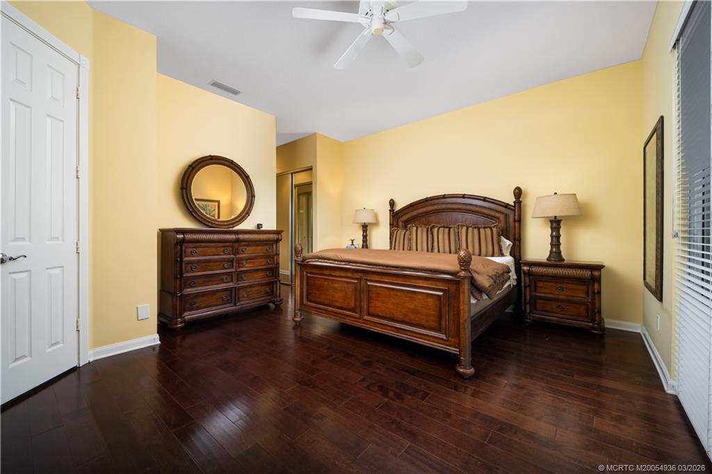 1477 Southwest Eagleglen Place Stuart, FL 34997 - Photo 14 of 36 a bedroom with a bed and wooden floor