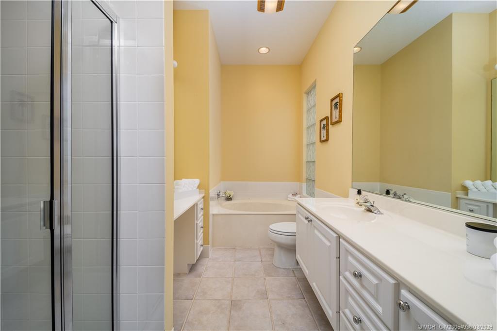 1477 Southwest Eagleglen Place Stuart, FL 34997 - Photo 16 of 36 a bathroom with a double vanity sink toilet and shower