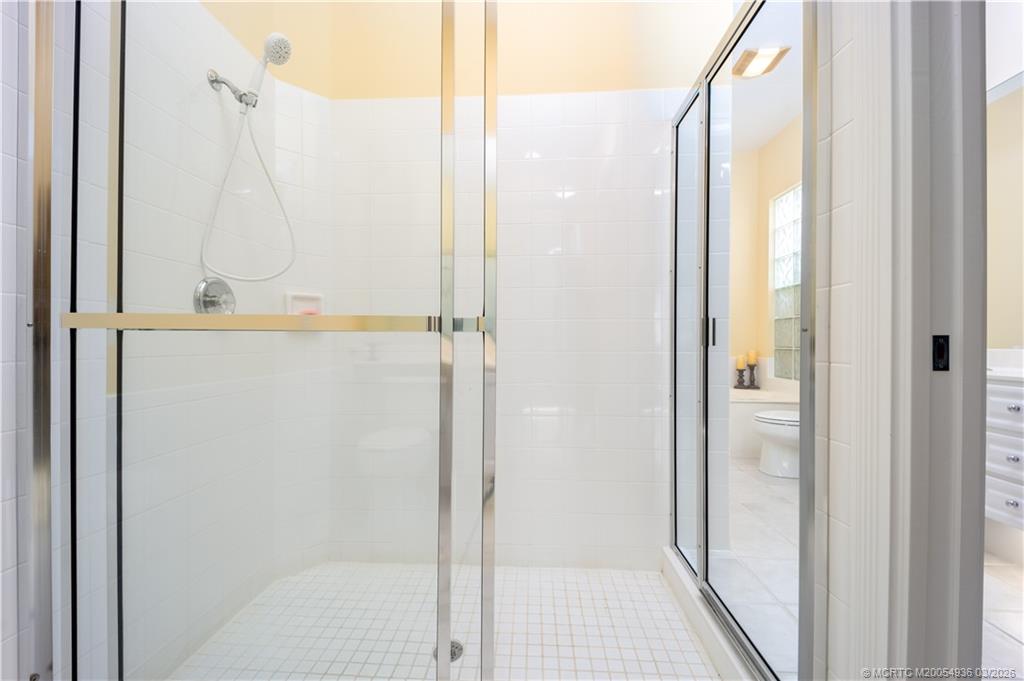1477 Southwest Eagleglen Place Stuart, FL 34997 - Photo 20 of 36 a bathroom with a glass shower door