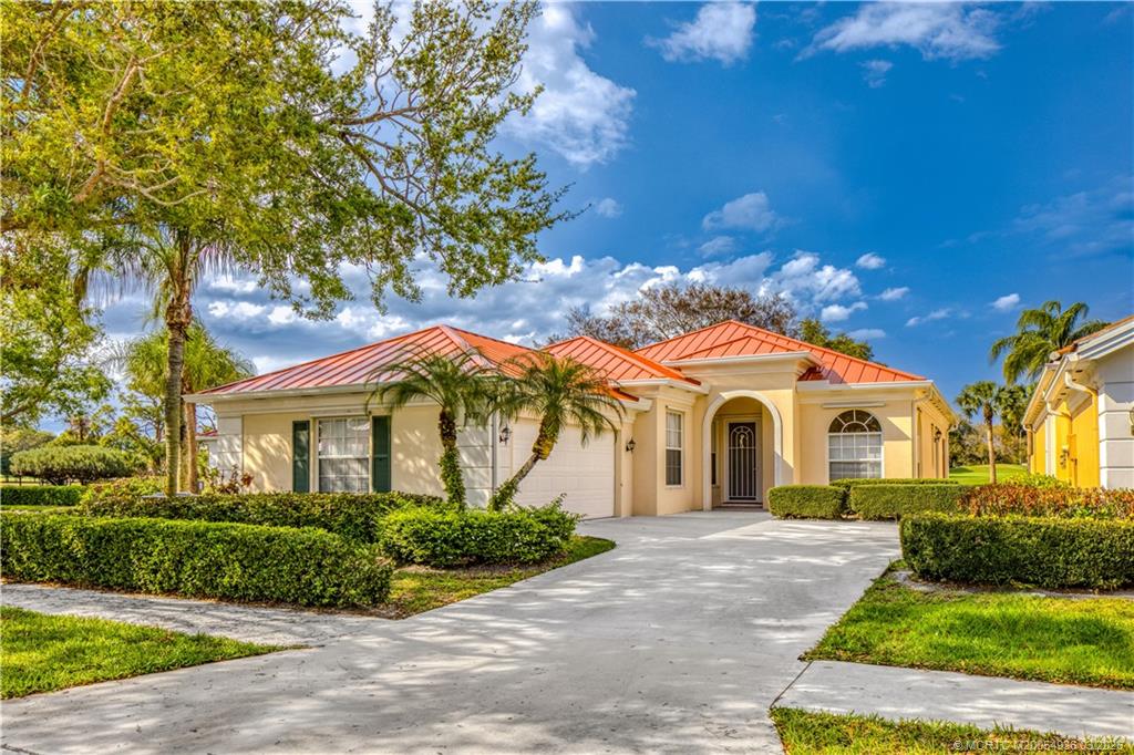 1477 Southwest Eagleglen Place Stuart, FL 34997 - Photo 2 of 36 a front view of a house with a yard