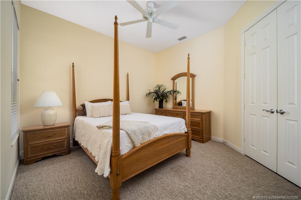 1477 Southwest Eagleglen Place Stuart, FL 34997 - Photo 22 of 36 a bed room with a bed and a night stand