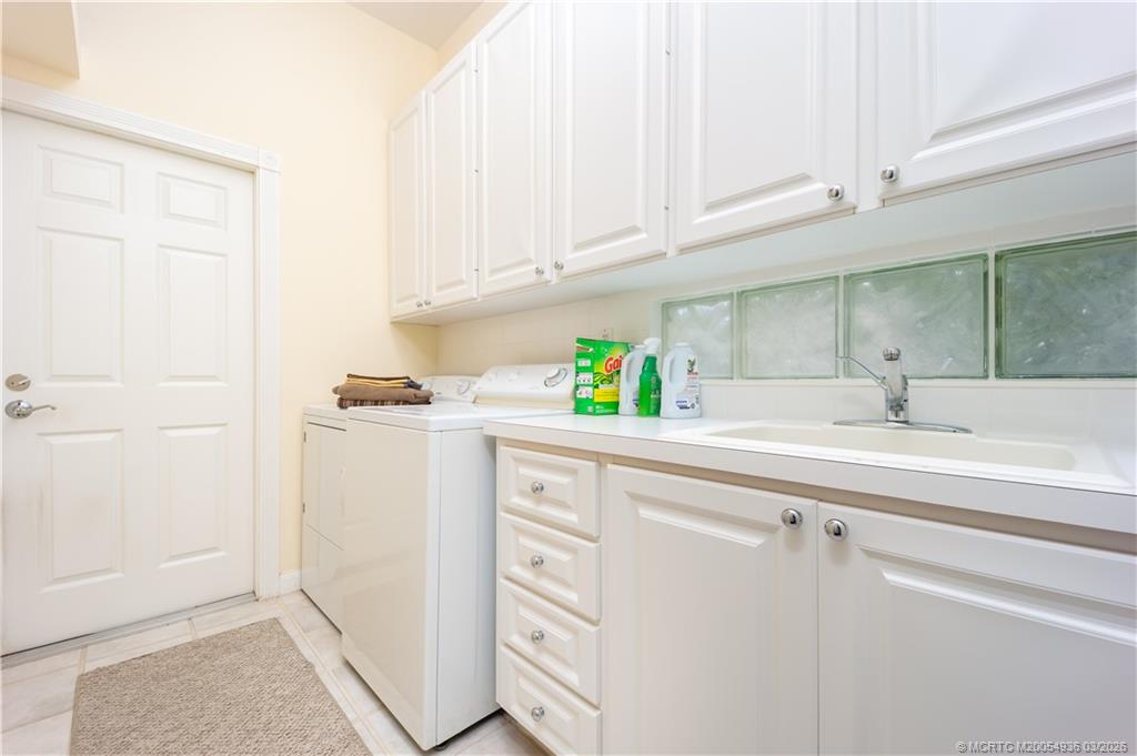 1477 Southwest Eagleglen Place Stuart, FL 34997 - Photo 25 of 36 a kitchen with white cabinets and white appliances