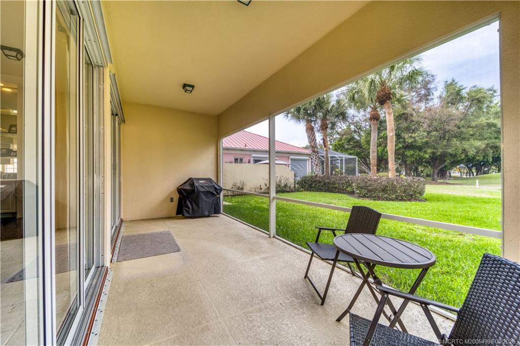 1477 Southwest Eagleglen Place Stuart, FL 34997 - Photo 26 of 36 a view of a patio with a table chairs and a yard