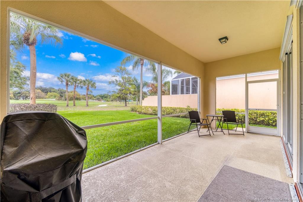 1477 Southwest Eagleglen Place Stuart, FL 34997 - Photo 27 of 36 a view of a porch with furniture and a yard