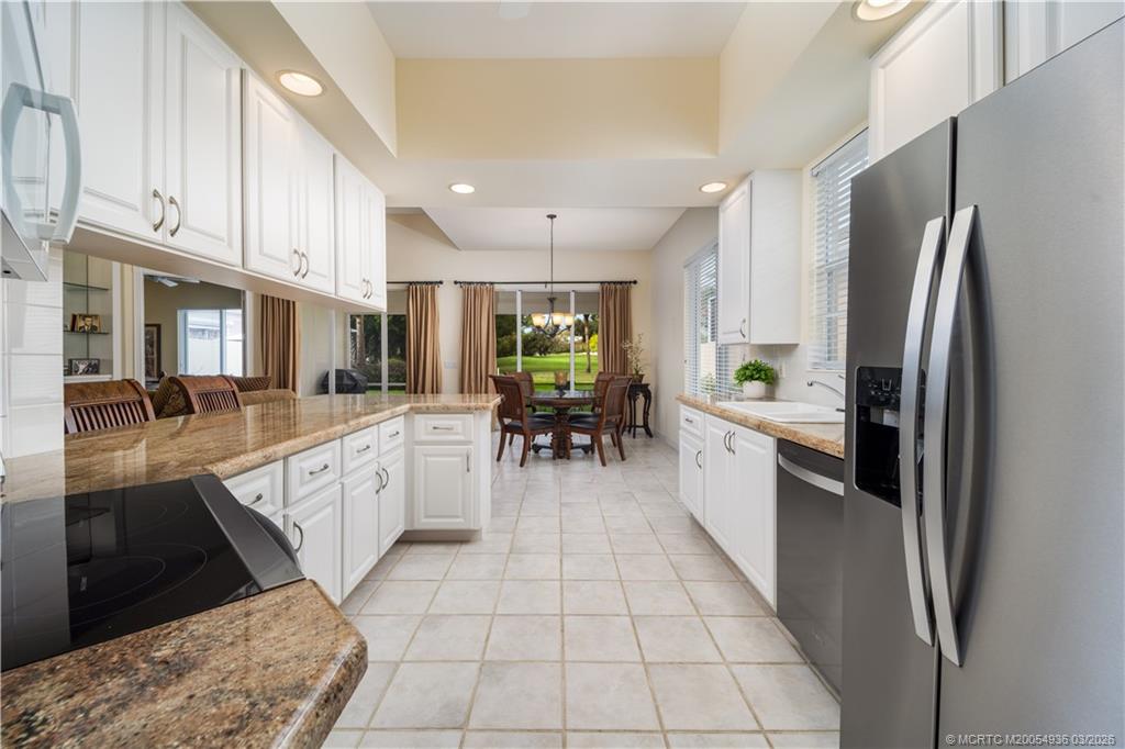1477 Southwest Eagleglen Place Stuart, FL 34997 - Photo 8 of 36 a large white kitchen with lots of appliances and cabinets
