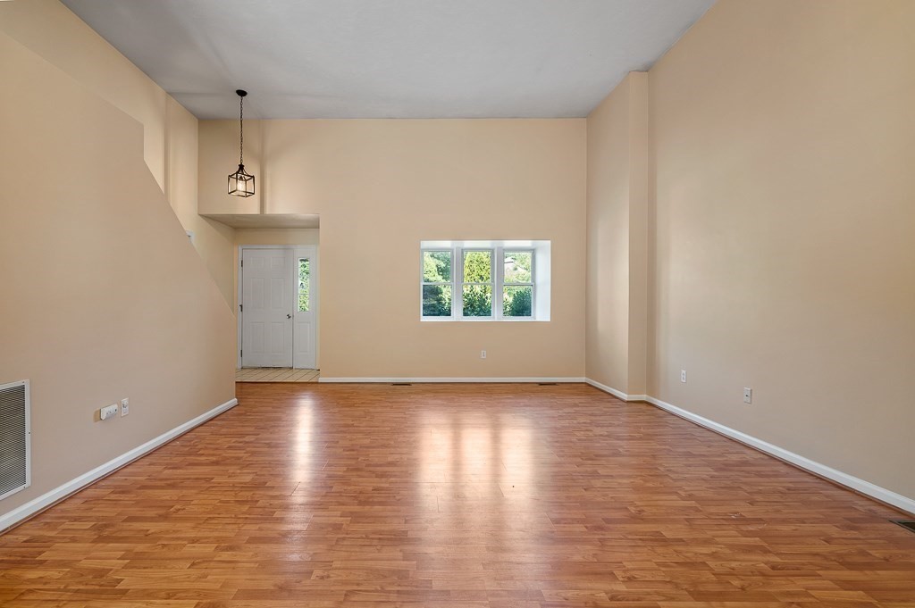 22 Highfield Road, Unit A Charlton, MA 01507 - Photo 3 of 26 a view of an empty room with wooden floor and a window