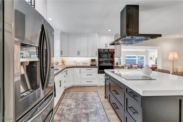a kitchen with stainless steel appliances granite countertop a sink and a refrigerator