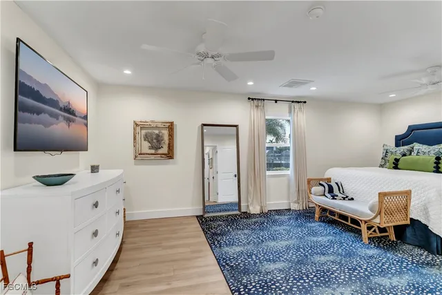 a spacious bedroom with a bed and flat screen tv