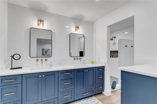 a bathroom with double vanity sinks and a mirror