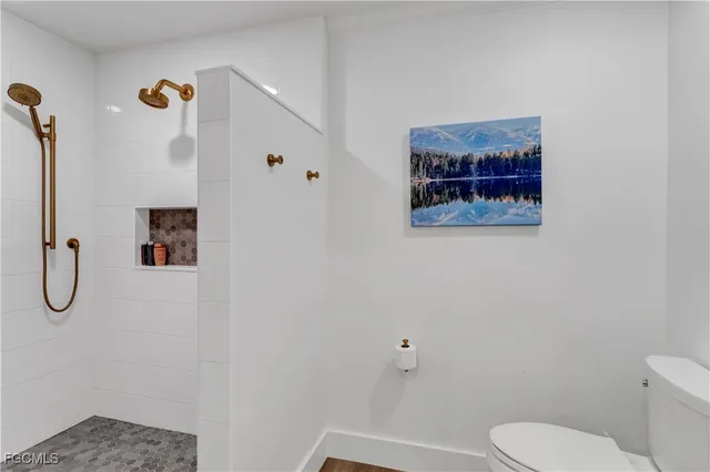 a bathroom with a toilet and a shower