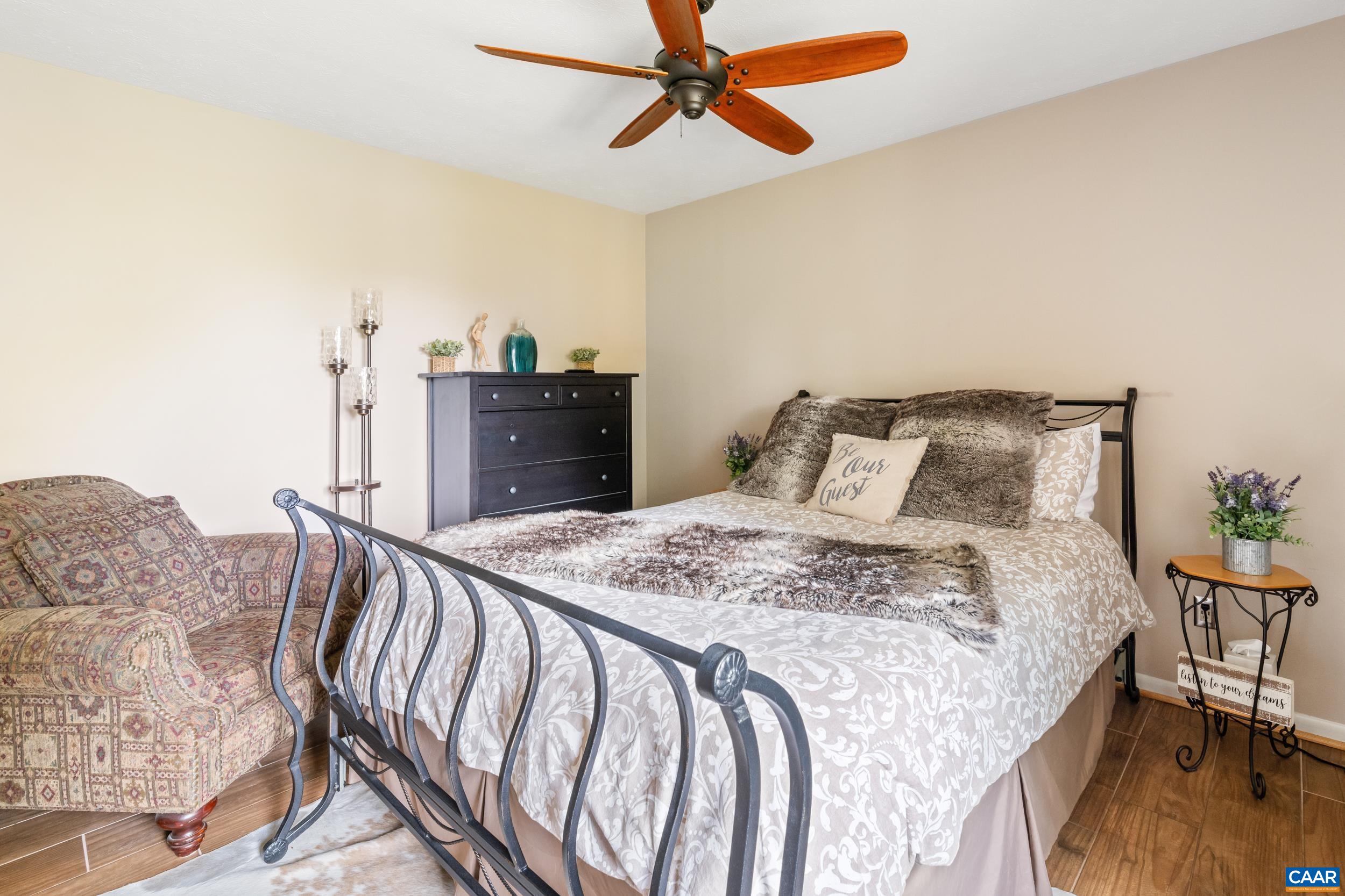 2225 Tanners Ridge Roseland, VA 22967 - Photo 13 of 26 a bed sitting in a bedroom next to a cabinet with a flat screen tv and couches