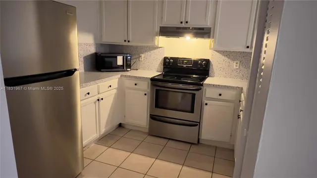 a kitchen with a refrigerator stove and cabinets