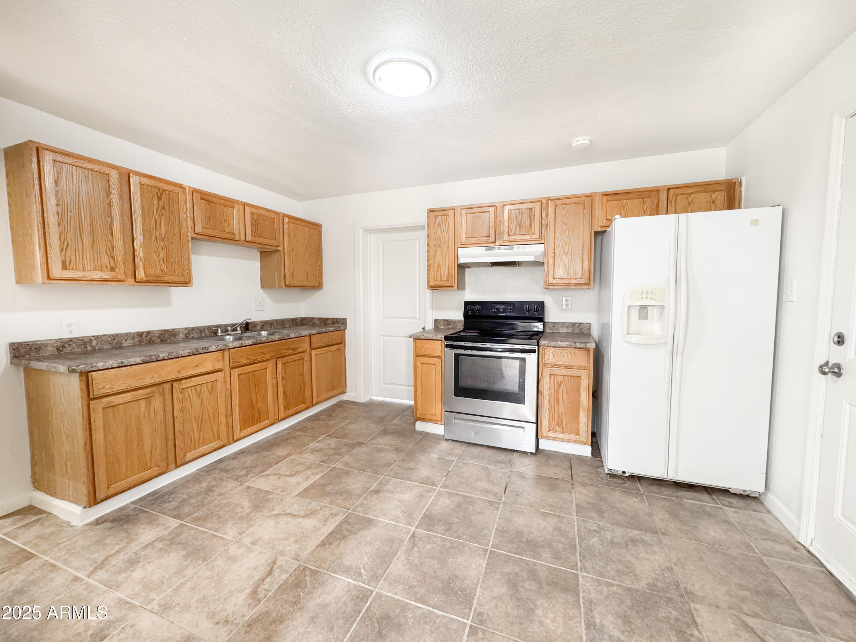 3422 East Culver Street Phoenix, AZ 85008 - Photo 7 of 25 a kitchen with stainless steel appliances granite countertop a stove a sink and a refrigerator