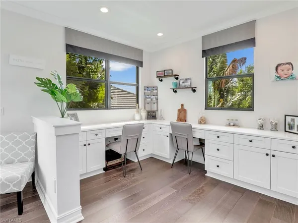 a view of a workspace with furniture and a window